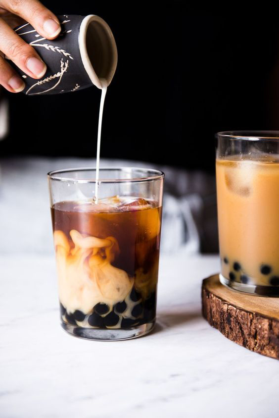 Milk tea being poured into a cup.